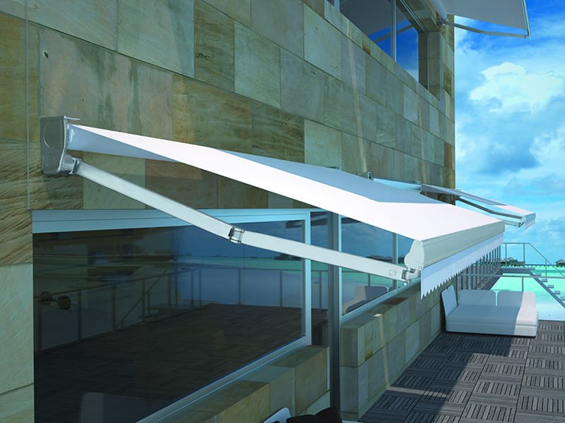 Toldo de brazo extensible instalado en una terraza frente al mar