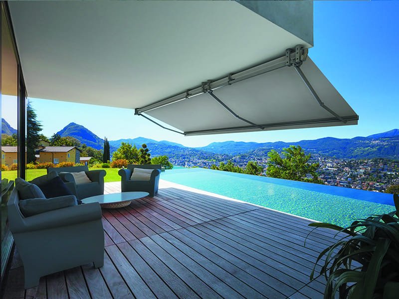 Toldo monobloc extendido sobre una terraza con piscina